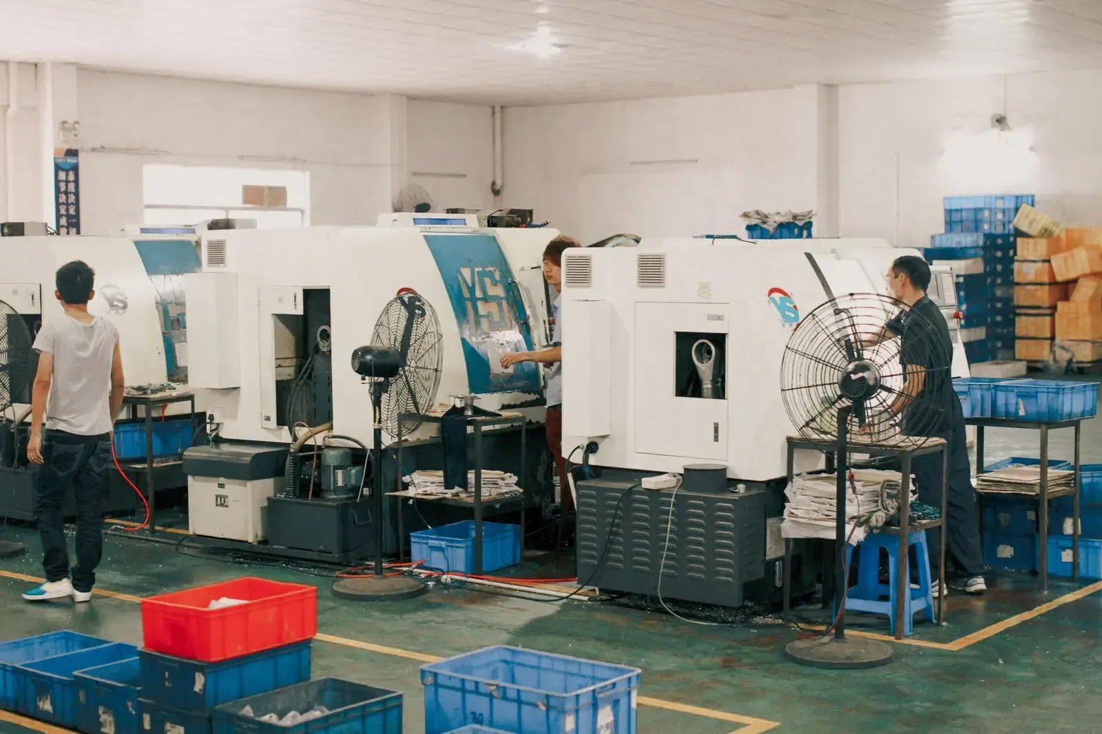 Machinists working at CNC machines in a machine shop