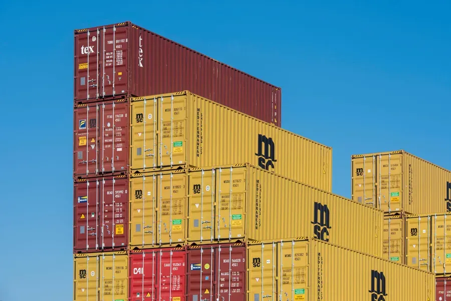 Stacked shipping containers against a blue sky