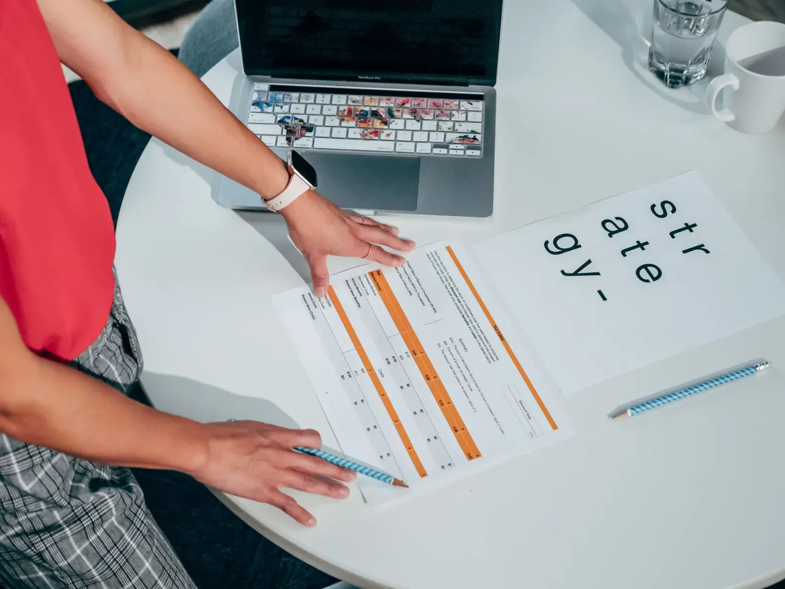 Hands comparing two printed documents at a desk