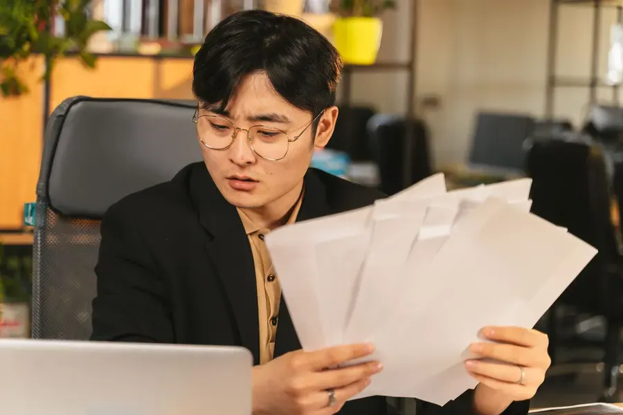 Buyer reading through supplier paperwork at his desk