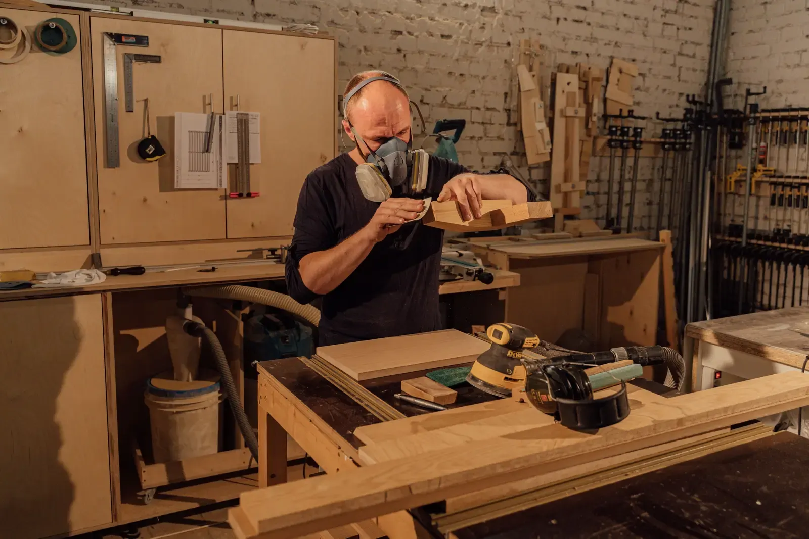 Craftsman finishing timber in a furniture workshop