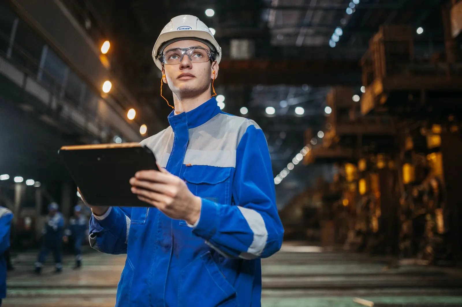 Engineer checking a tablet on a factory floor